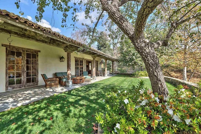 view of yard featuring a patio and french doors