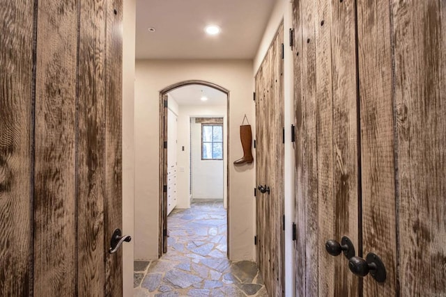 corridor with stone floors and arched walkways