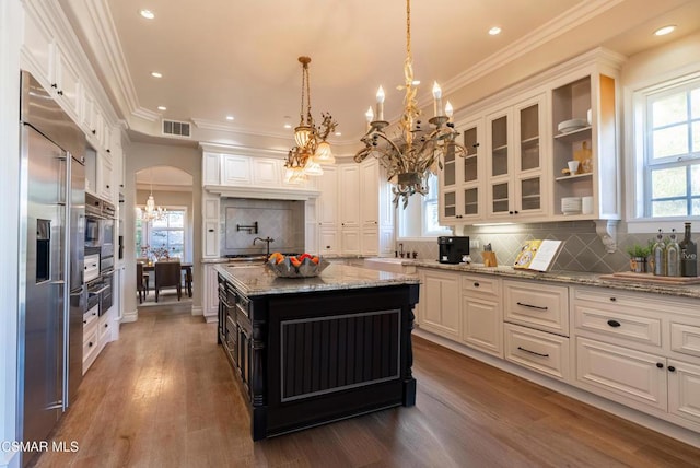 kitchen featuring white cabinetry, decorative light fixtures, dark hardwood / wood-style flooring, a kitchen island, and stainless steel appliances