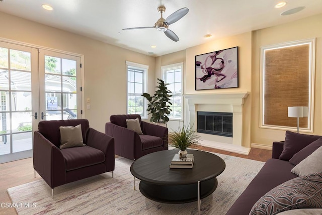 living room with light hardwood / wood-style flooring, ceiling fan, and french doors