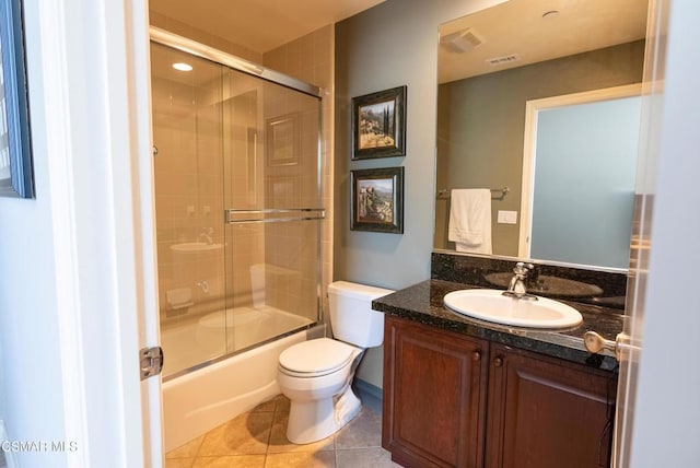 full bathroom with vanity, tile patterned floors, combined bath / shower with glass door, and toilet