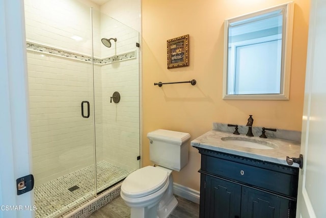 bathroom featuring vanity, toilet, and a shower with door