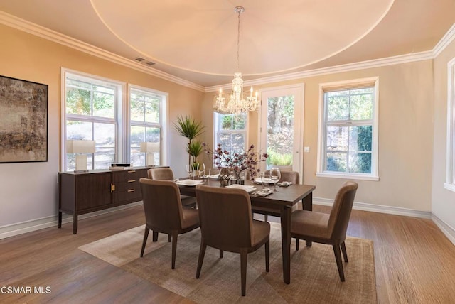 dining area featuring ornamental molding, a wealth of natural light, and light wood-type flooring