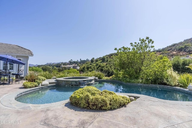 view of pool with an in ground hot tub and a patio