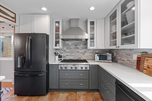 kitchen with white cabinetry, appliances with stainless steel finishes, gray cabinetry, and wall chimney range hood