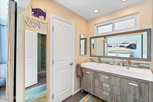 bathroom featuring vanity and backsplash