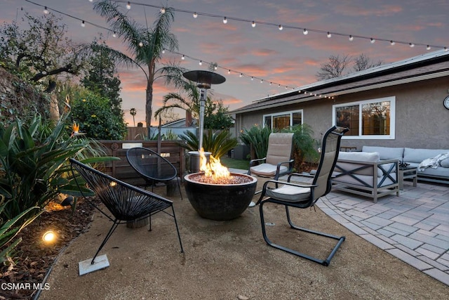 patio terrace at dusk featuring an outdoor living space with a fire pit