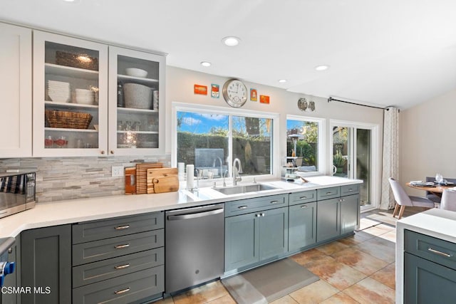 kitchen with appliances with stainless steel finishes, sink, light tile patterned floors, and backsplash