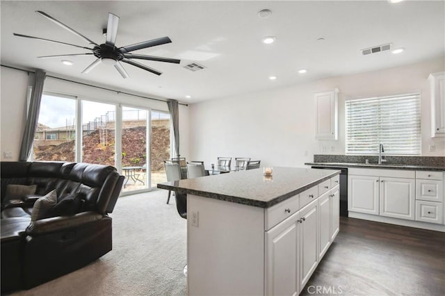 kitchen with sink, ceiling fan, a center island, black dishwasher, and white cabinets