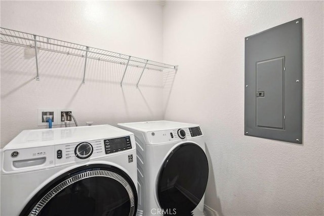 laundry room featuring electric panel and washing machine and clothes dryer