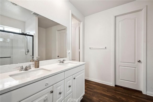 bathroom featuring vanity, a shower with door, and wood-type flooring