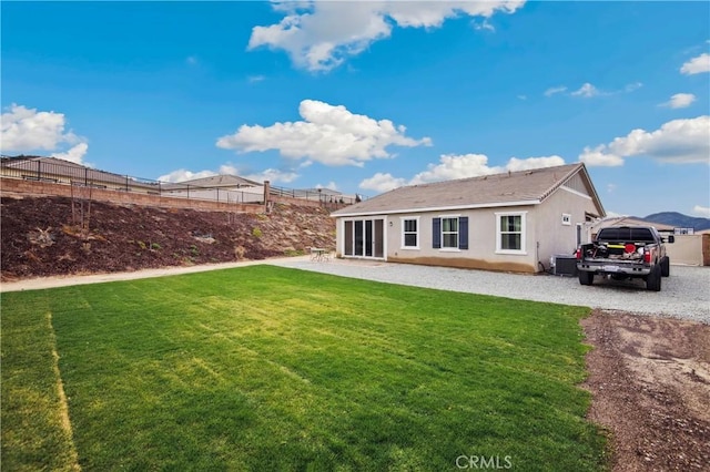 back of house with central AC unit and a yard