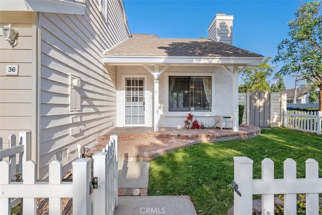 view of exterior entry with a yard