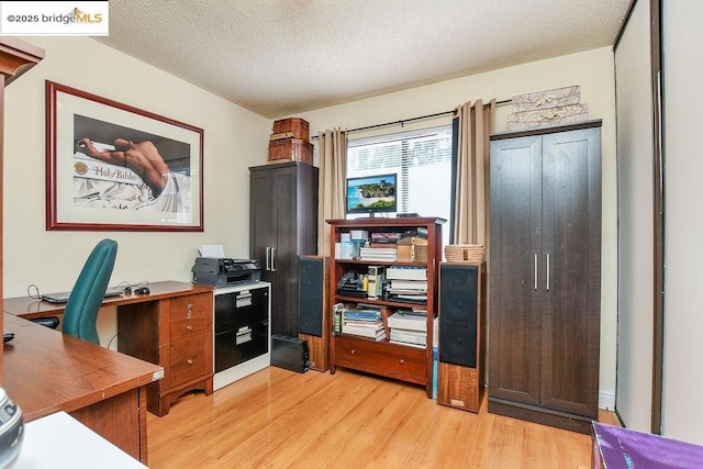 office space featuring light hardwood / wood-style floors and a textured ceiling