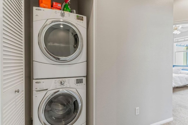 clothes washing area featuring carpet and stacked washer / dryer