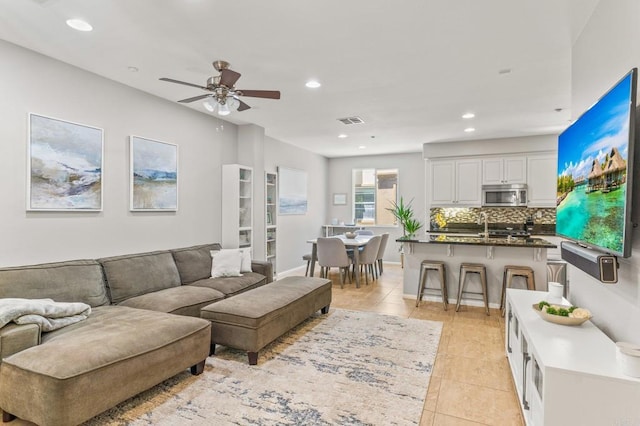 living area with visible vents, a ceiling fan, recessed lighting, light tile patterned flooring, and baseboards