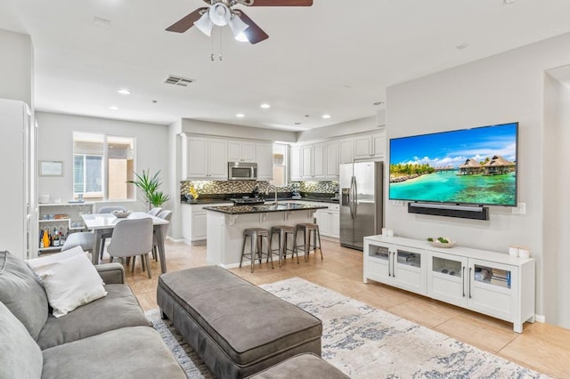 living area featuring light tile patterned floors, visible vents, ceiling fan, and recessed lighting