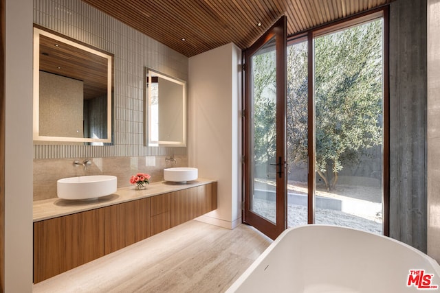 bathroom with tasteful backsplash, a wealth of natural light, a washtub, and wooden ceiling