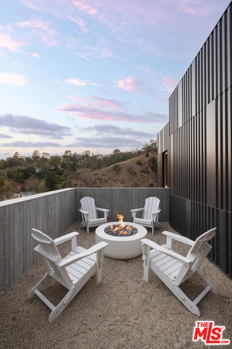 patio terrace at dusk featuring an outdoor fire pit