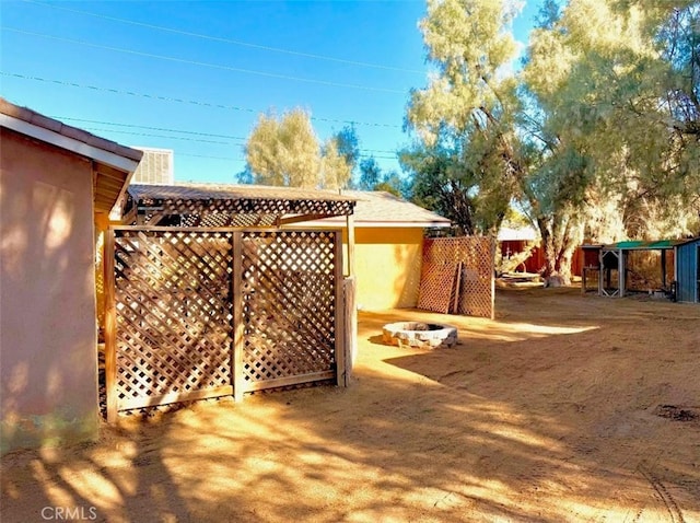 view of yard with an outdoor fire pit and fence