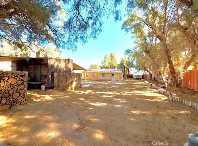 rear view of house featuring a chimney and fence