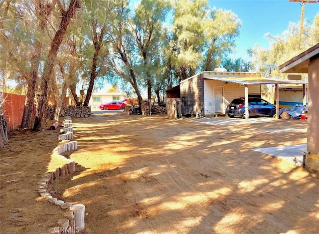 exterior space with driveway, fence, and a carport