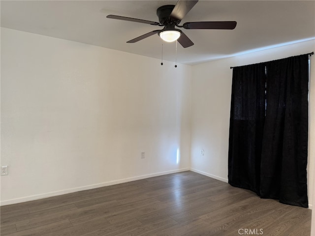 empty room with ceiling fan, baseboards, and dark wood finished floors