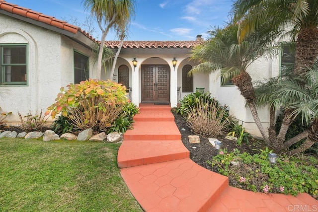 doorway to property with french doors and a lawn