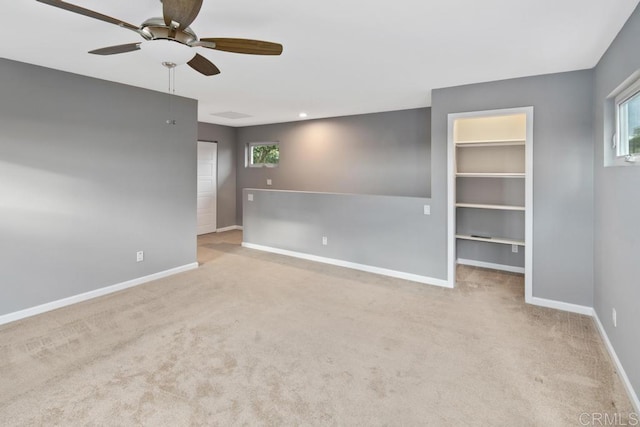 spare room featuring carpet flooring, a ceiling fan, and baseboards