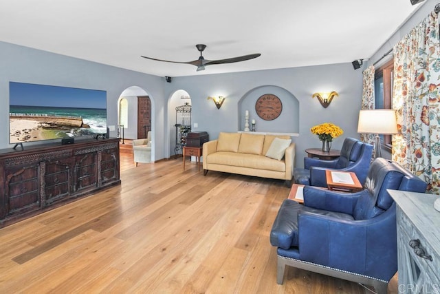 living room with arched walkways, ceiling fan, and wood finished floors