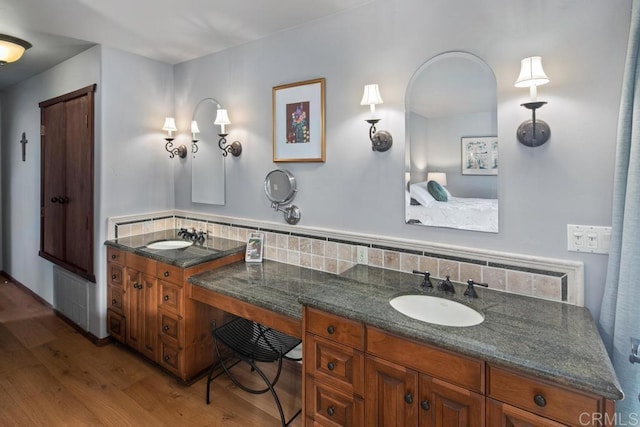 full bathroom with tasteful backsplash, a sink, and wood finished floors