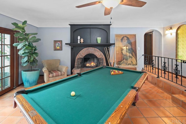 rec room featuring pool table, a brick fireplace, tile patterned flooring, and a ceiling fan