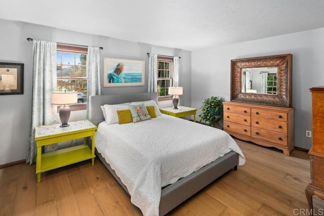 bedroom with wood-type flooring and baseboards