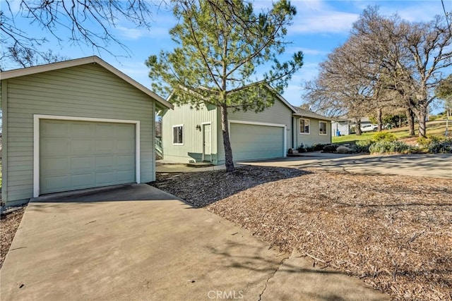 single story home with an outbuilding and concrete driveway