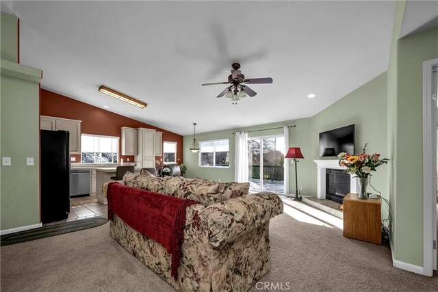 carpeted living room featuring vaulted ceiling and ceiling fan