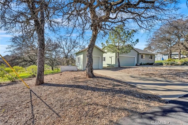 view of property exterior featuring a garage and concrete driveway