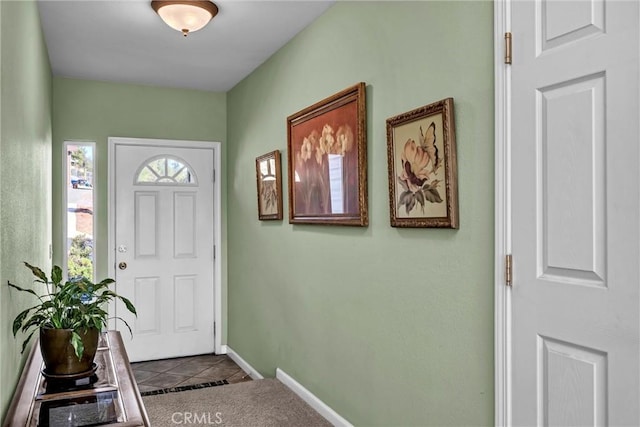 entrance foyer featuring dark tile patterned floors and baseboards