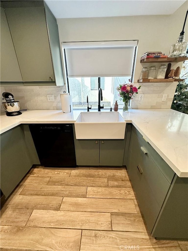 kitchen with green cabinetry, light hardwood / wood-style floors, sink, backsplash, and dishwasher