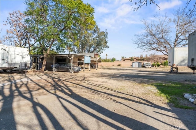 exterior space with a storage shed, a carport, and an outdoor structure