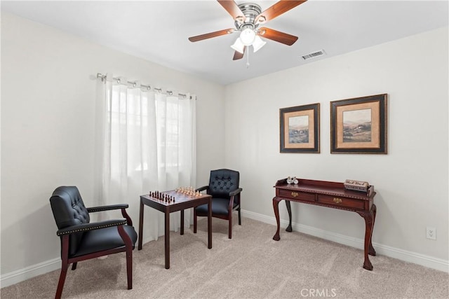 living area featuring light carpet and ceiling fan