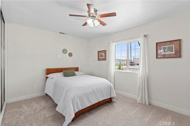 carpeted bedroom with a ceiling fan, visible vents, and baseboards