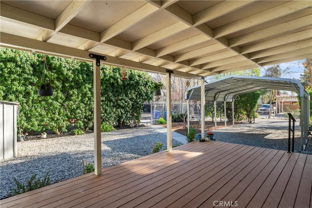 deck with fence and a detached carport