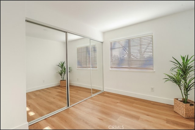 unfurnished bedroom with wood-type flooring and a closet