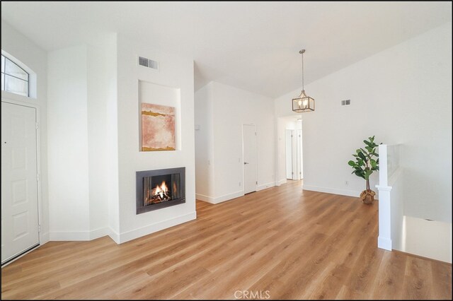 unfurnished living room with light hardwood / wood-style flooring and high vaulted ceiling