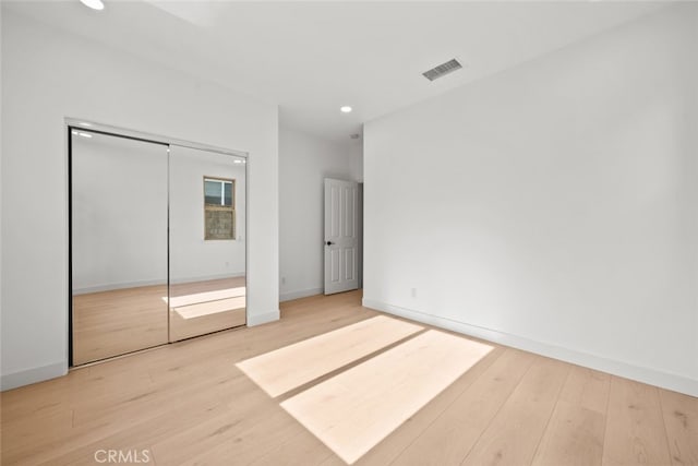 unfurnished bedroom featuring hardwood / wood-style floors and a closet