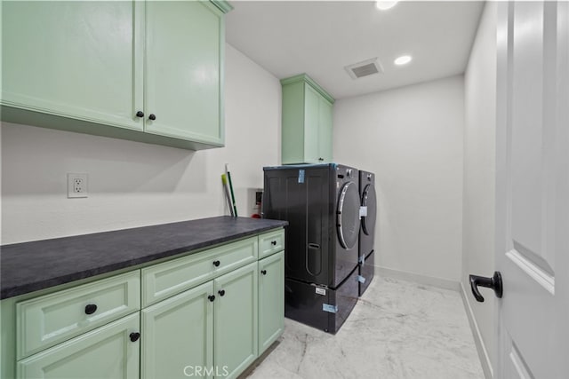 laundry room featuring washing machine and dryer and cabinets