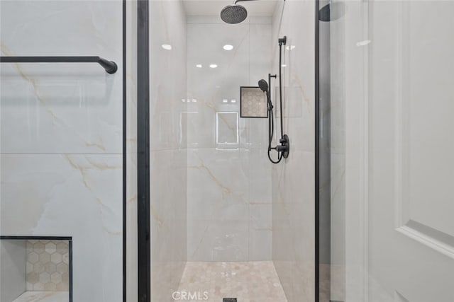 bathroom with a shower with door