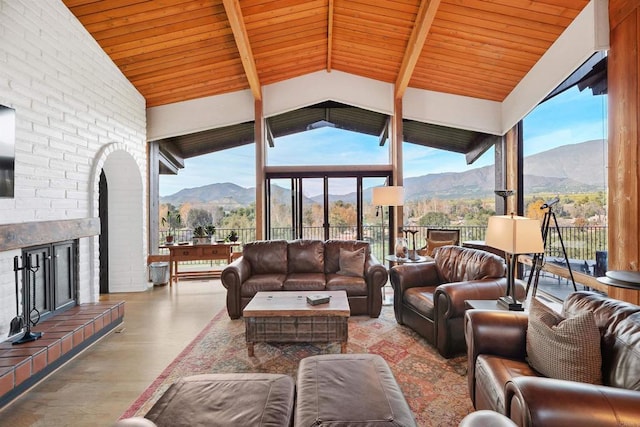 living room featuring wood ceiling, a mountain view, lofted ceiling with beams, and a brick fireplace