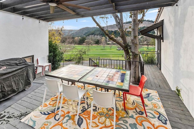 wooden terrace with a mountain view and ceiling fan