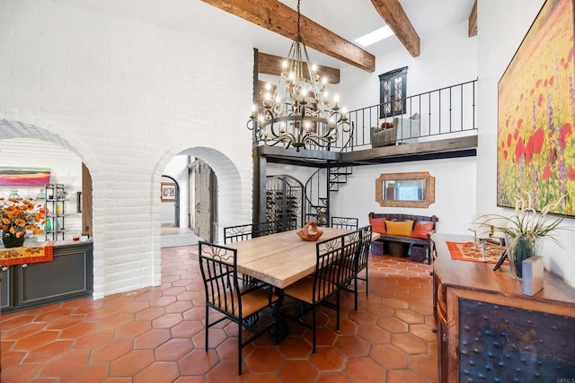 tiled dining room with beamed ceiling and a high ceiling